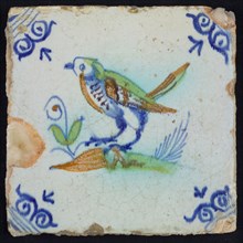 Animal tile, bird on ground to the left in orange, brown, green and blue on white, corner motif oxen head, wall tile