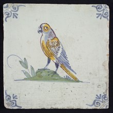 Animal tile, bird on ground to the left in yellow, purple, green and blue on white, corner pattern ox head, wall tile