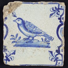 Animal tile, bird on plot to the left between balusters in blue on white, corner pattern french lily, wall tile tile sculpture