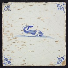 Animal tile, fish in water to the right with open beak and curled tail, in blue on white, corner pattern ox-head, wall tile