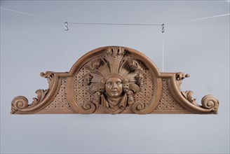 Carved and painted wooden standing ornament with head surrounded by curly leaves in the middle, ornament wood carving sculpture