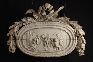 Carved wooden ornament with putti and goat, in oval frame, crowned with wreath of oak leaves, ornament wood carving sculpture