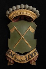 Carved wooden crowned coat of arms including the name M.M. Van der Loeff, coat of arms information form carvings sculpture