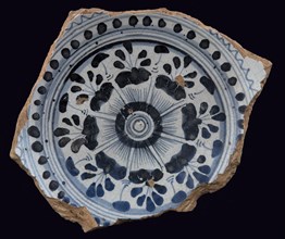 Fragment majolica plate, blue on white, stylized floral pattern on mirror, dot and serrated edge surrounded by concentric