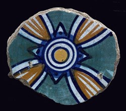 Fragment majolica dish, green, orange, yellow and blue on white, ornamental motif with four ellipses and four leaves