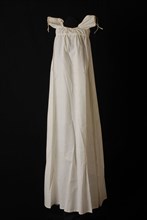 Long slip dress of christening dress, of white cotton, smooth, without any decoration, high waist and puff sleeves, christening
