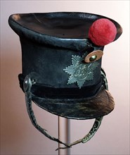 Shako of black felt, leather and velvet band, blank metal emblem JE MAINTIENDRAI and metal fittings on leather belt, red pompon
