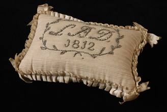 Pincushion with striped white cotton covered, all-round pleated ribbon, initials and dates inscribed with pins on both sides