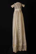 Baby dress of white batiste with white-embroidered straw motif, embroidered bodice and two garland edges along the hem