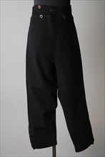 Breeches of black cloth, flap closure on the lap, buttons along the bottom of the leg, part of boy's suit, shorts pants suit