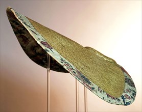 Large semi-circular sun hat, natural colored ribbon straw, low flat ball, very wide rim, lining of chintz and edge of pleated