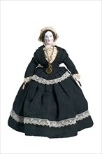 mw. Andres-Van Embden, Dollhouse doll, painted porcelain face with pink complexion, wooden arms, fabric body and legs, dressed