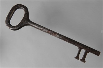 Large iron key with oval eye, elongated massive key handle and simple cross-shaped notches, key iron iron, hand forged Key