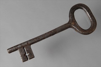 Iron key with oval eye, elongated solid key handle and simple cruciform barrels in beard, key iron value iron, hand forged Key