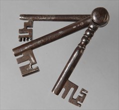Three different iron keys, consisting of key stems with beards, which are hinged to each other at the top of the handle, key