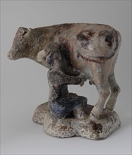 Standing cow with sitting milker in 18th century costume, damaged by fire from bombing Rotterdam May 1940, sculpture visual