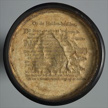 One-sided wooden medallion, covered with paper, with printed text OP DE HELDEN-BEELDEN, penny box holder of wood paper, Text