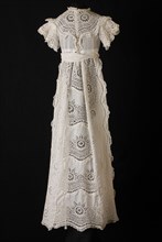 Long wide baby dress in white cotton, front, over sleeves and wide front on the skirt of coarse embroidery with large wheel