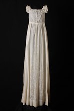 Long flared christening dress of white batiste, V-shaped front with plumetis embroidery, also on the skirt, short sleeves