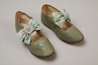 Mint green leather children's shoes with instep strap on which satin bow with decorative button, strap has button closure