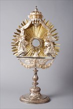 Driven gilded silver monstrance with angels on halo, monstrance liturgical vessel holder silver gold glass, City sign Rotterdam