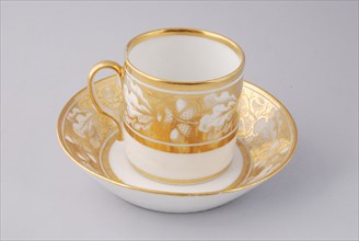 White cup and saucer with gold colored band with acorn and leaf decoration, cup and saucer drinking utensils tableware holder