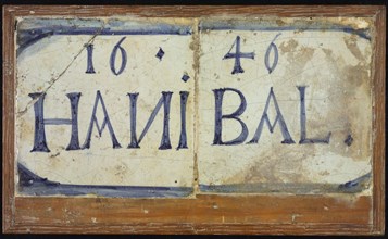 Two tiles next to each other in wooden frame, blue on white, outlined in blue: 1646 and HANIBAL, tile picture material ceramic