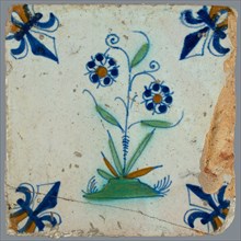 Flower Tile, flower on ground in orange, green and blue on white, corner pattern French lily, corner point orange, wall tile