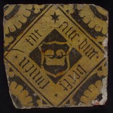 Heraldic tile, floor tile in dark brown and white, overhoekse ruit with coat of arms, wide edge gothic inscription, corner motif