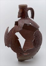Fragments of stoneware Bartmann jug, also called Bellarmine jug, dark brown, on stand, beardmug tableware holder soil find