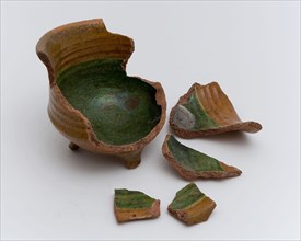 Fragments earthenware cooking jug, completely lacquered in green and brown, on three legs, cooking jug
