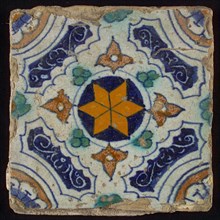 Tile, blue, green, brown and yellow on white, central an orange star in circle, sgraffito surfaces, corner motif quarter rosette