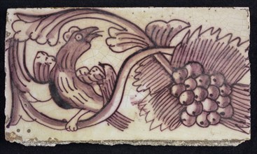 Rectangular edge tile in purple with serpentine decor of leafy tendril, toasted bird to the right, grape bunch, edge tile wall