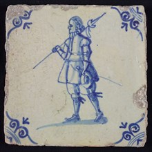 White tile with blue warrior with spear, sword and hat in hands; corner pattern ox head, wall tile tile sculpture ceramics