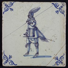 White tile with blue warrior with spear and plume helmet; corner pattern ox head, two shades of blue, wall tile tile sculpture