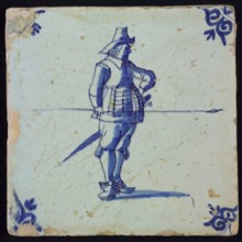 White tile with blue warrior with spear and hand in side; corner pattern ox head, wall tile tile sculpture ceramic earthenware