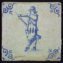 White tile with blue warrior with helmet, loading his rifle; corner pattern ox head, wall tile tile sculpture ceramic