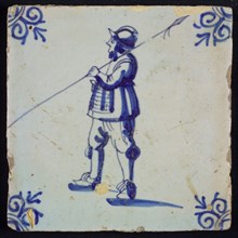 White tile with blue warrior with spear and helmet; corner pattern ox head, wall tile tile sculpture ceramic earthenware glaze