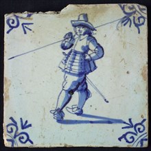 White tile with blue warrior with hat and spear over shoulder; corner pattern ox head, wall tile tile sculpture ceramic
