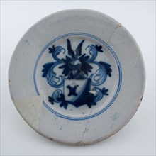Faience plate on stand surface, decoration coat of arms with winged helmet in blue on white background, plate crockery holder