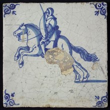 White tile with blue horseman with armor, shield and sword; corner pattern ox head, wall tile tile sculpture ceramic earthenware