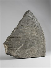 Fragment millstone of dark gray natural stone, millstone tools equipment soil finds natural stone stone 38.0 w 45.7 sawn