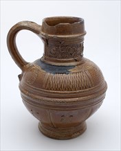 eter Knötgen (?), Brown stoneware jug, ear with tail, round neck frieze with circles and masks, hearts, signed, crockery holder