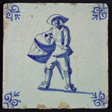 White tile with blue warrior with drum and hat; corner pattern ox head, wall tile tile sculpture ceramic earthenware glaze