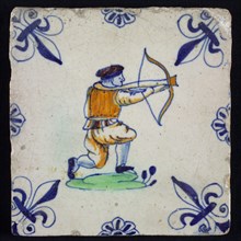 White tile with kneeling archer in yellow, green and blue, corner pattern french lily in blue and rim decoration of rosettes