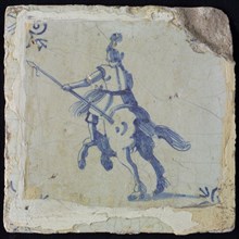 White tile with blue horseman with spear, seen from behind; corner pattern ox head, wall tile tile sculpture ceramic earthenware