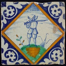 White tile with blue soldier with rifle on hill in yellow and green in squared, palm with corner motif, wall tile tile sculpture