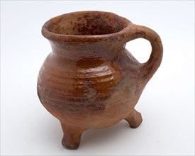 Pottery cooking jug, grape-model, red shard, sparingly glazed, vertical sausage ear, on three legs, cooking jug