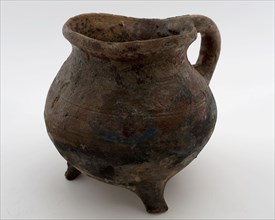 Pottery cooking jug, grape-model, red shard with sparing lead glaze, sausage ear, on three legs, cooking jug