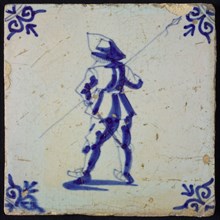 White tile with blue warrior with spear, seen from behind; corner pattern ox head, wall tile tile sculpture ceramic earthenware